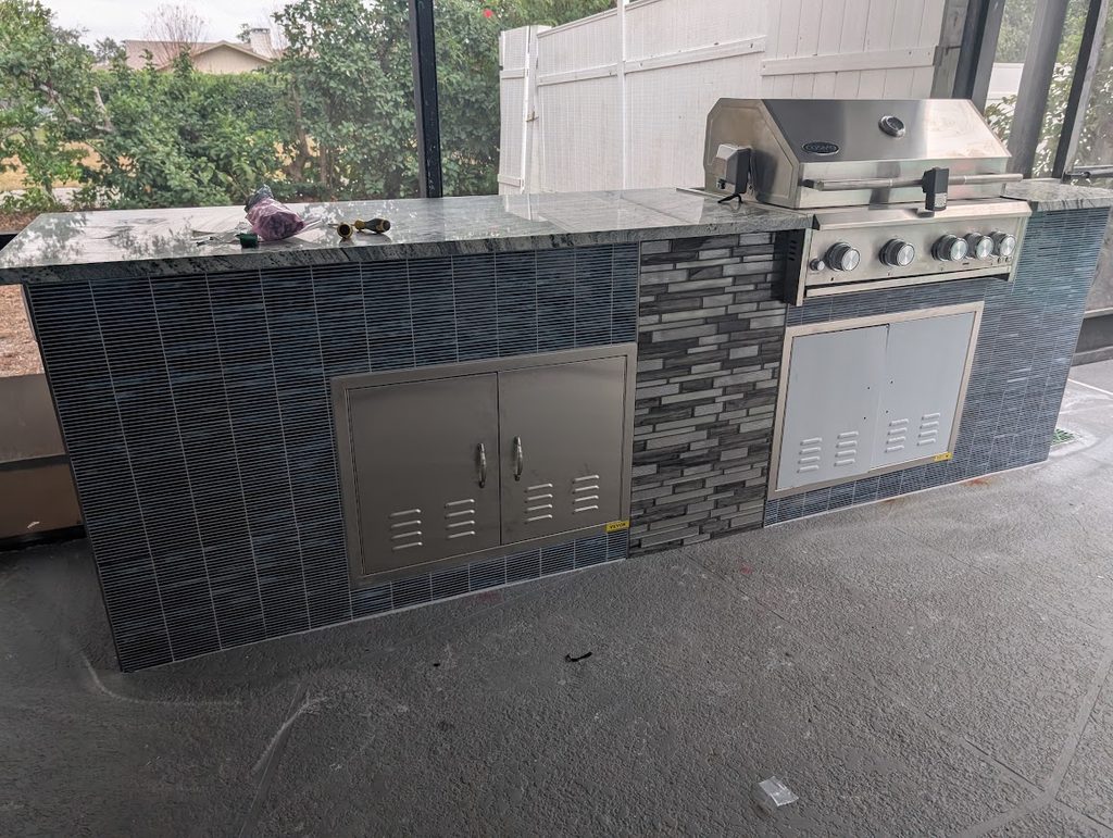 Tiled island with stainless doors and integrated lighting